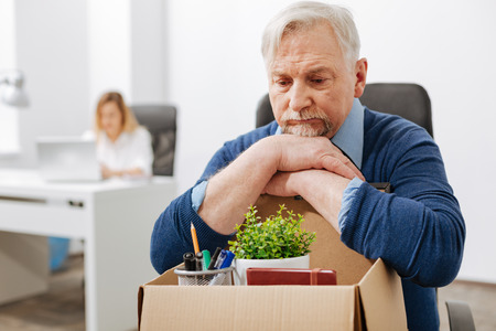 Depressed employee gathering personal documents into the boxの写真素材
