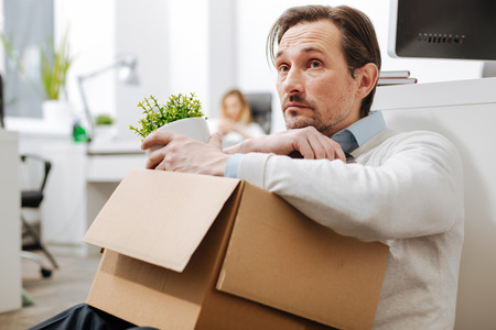 Fired depressed man sitting on the floor in the office