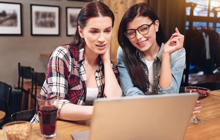 Delighted attractive women watching something