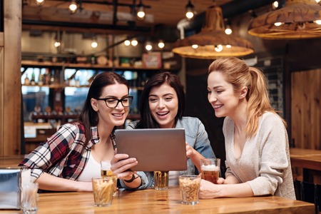 Positive delighted brunette holding her device in right handの写真素材