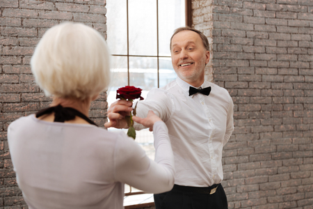 Smiling senior man dancing with aged woman in the ballroomの写真素材