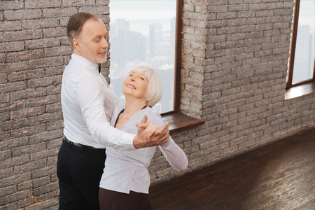 Delighted pensioners waltzing in the dance studioの写真素材