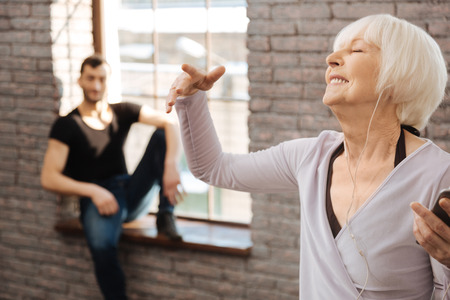 Delighted retired woman enjoying music during the dance classの写真素材