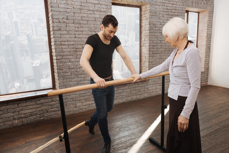 Mature dance teacher instructing aged woman in the ballroomの写真素材