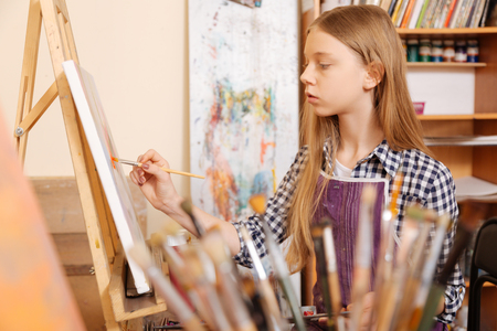 Positive young girl practicing painting in the art schoolの写真素材