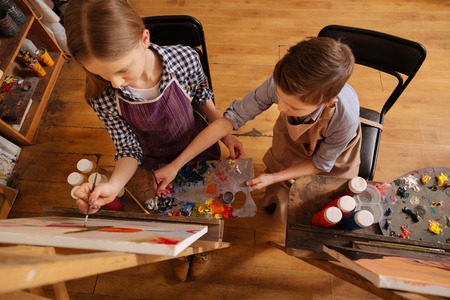 Creative children painting together at schoolの写真素材