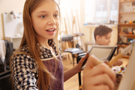 Lively girl making the art reproduction during art sessionの写真素材