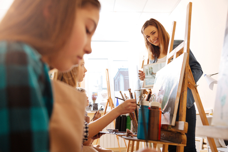 Smiling young teacher using modern gadget in the studioの写真素材