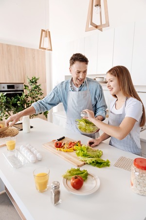 POsitive man cooking with his daughter in the kitchenの写真素材