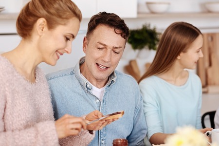 Positive couple having breakfast with their daughterの写真素材