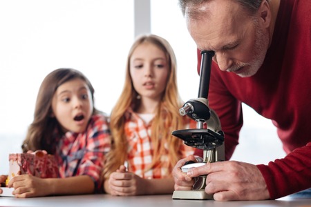 Emotional excited children watching at their teachers workの写真素材