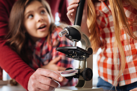 Attentive biology teacher adjusting a microscope glassの写真素材