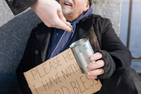 Close up of poor man holding tin for coinsの写真素材