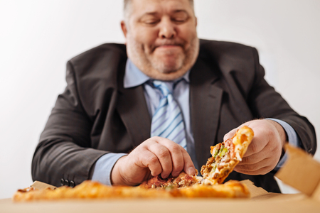 Puffy hungry office worker enjoying his lunchの写真素材