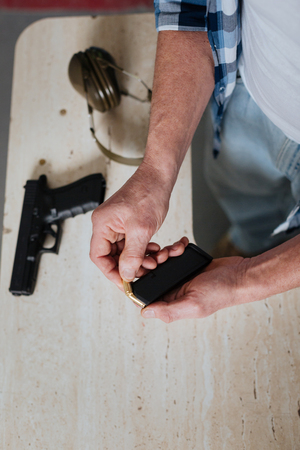 Handsome brutal man holding the cartridge clipの写真素材