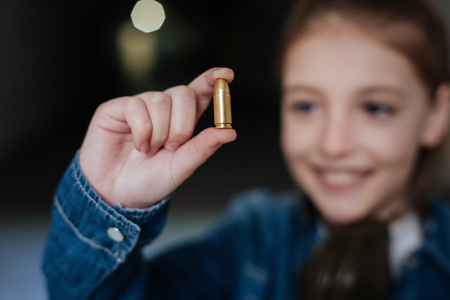 Selective focus of a bullet being held by a girlの写真素材