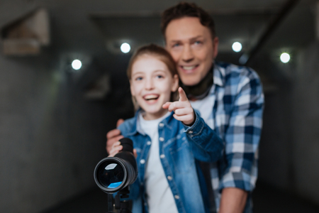 Cheerful cute girl showing something to her fatherの写真素材