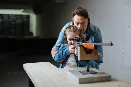 Nice delighted father and daughter in the shooting rangeの写真素材