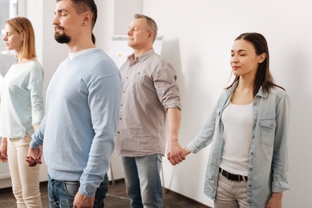 Photo of delighted coworkers standing in semi position
