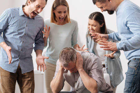 Young colleagues shouting at their coworkerの写真素材