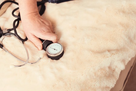 Aged woman holding tonometer at homeの写真素材