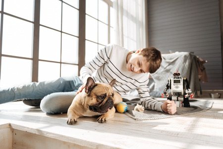 Happy man-child staring on his dogの写真素材