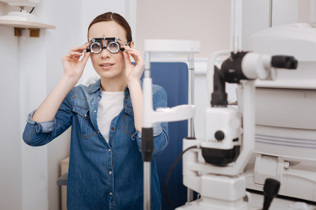 Beautiful good looking woman putting on eye test glasses