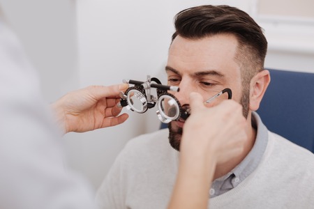 Nice female doctor giving eye test glasses to her patientの写真素材