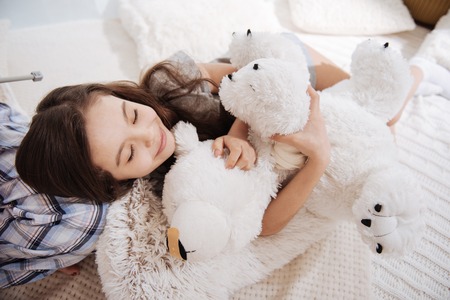 Charming little girl sleeping in the bedroomの写真素材