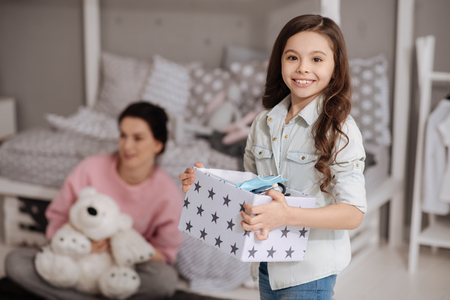 Cheerful little girl enjoying weekend with mother at homeの写真素材