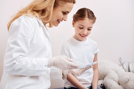 Smiling family doctor showing box for tabletsの写真素材