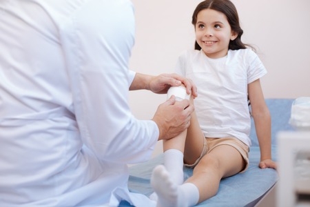 Positive cute girl looking at her doctorの写真素材