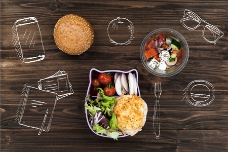Freshly baked bun lying near bowl with saladの写真素材