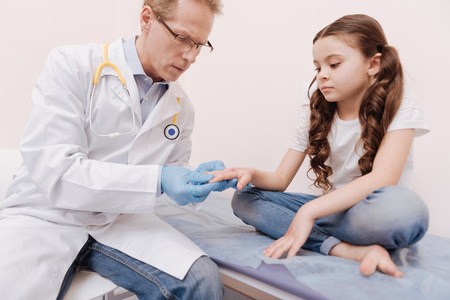 Prominent skillful specialist having a look at childs handsの写真素材