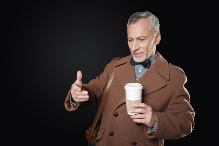 Positive delighted man in years looking at his hand