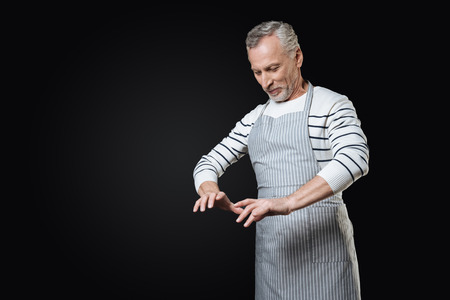 Smiling man looking at his fingersの写真素材