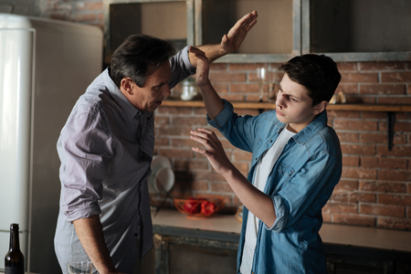 Angry father lifting his arm on sonの写真素材