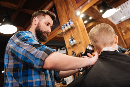 Professional handsome barber holding a hair cutting machineの写真素材