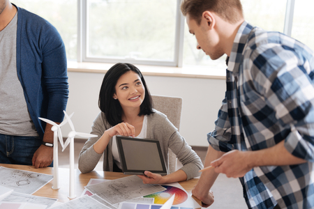 Pleasant pretty woman showing her colleague a pictureの写真素材