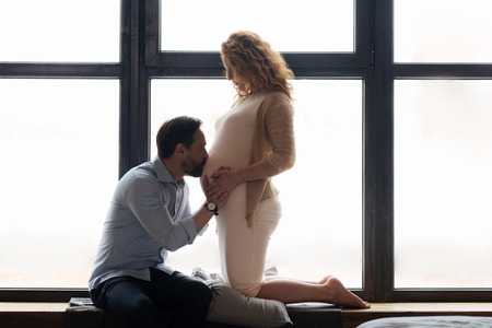 Adorable moment of husband kissing baby bump