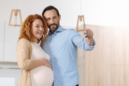 Parents-to-be looking at keys to new houseの写真素材