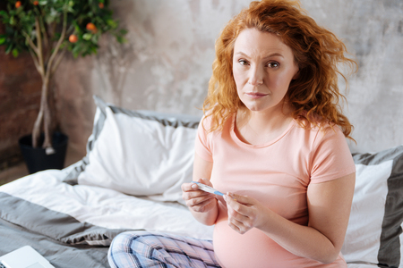 Mature mom-to-be taking her temperatureの写真素材