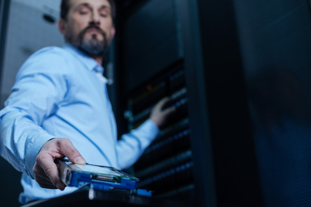 Handsome bearded programmer taking a rack serverの写真素材