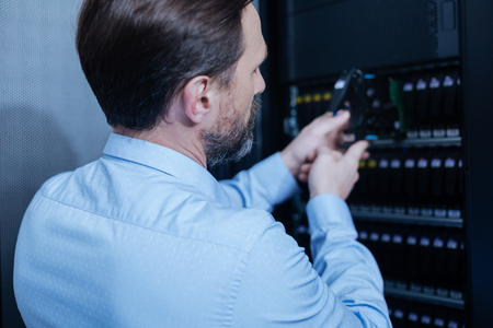 Handsome professional technician working in the data centerの写真素材