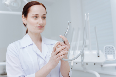 Surprised woman in white smock standing in dentist cabinetの写真素材