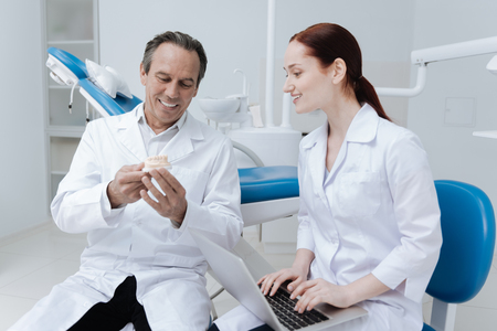 Positive delighted male person holding model of jawの写真素材