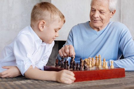 Excited lively man watching at grandsons reactionの写真素材