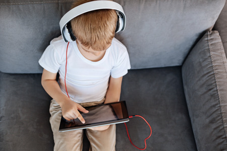 Lively focused kid using his tabletの写真素材