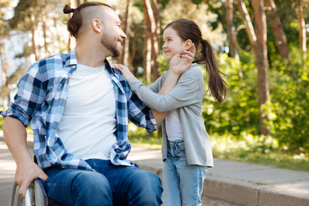Delighted man touching ear of his daughterの写真素材