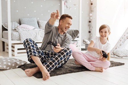 Emotional dad and his daughter playing video games